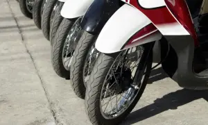Rzędy motocykli gotowe do dpd transportu. Widoczne koła, opony i błotniki w kolorze białym, czarnym i czerwonym.