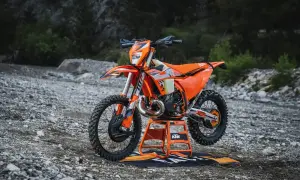 Pomarańczowy KTM EXC 300 2T na stojaku, gotowy do jazdy w terenie. Sprawdź jego dane techniczne!