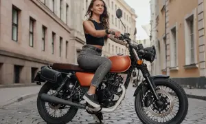 Dziewczyna na motocyklu 125, gotowa na jazdę po mieście. Stylowa, pewna siebie, z uśmiechem na twarzy.