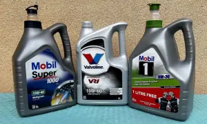 Trzy bańki z olejem silnikowym: Mobil Super 1000, Valvoline VR1 i Mobil 1. Wybór między olejem syntetycznym czy mineralnym zależy od potrzeb silnika.