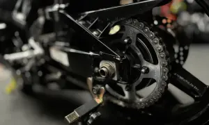 Zbliżenie na zębatkę i łańcuch motocyklowy. Dowiedz się, czym czyścić łańcuch motocyklowy, by był jak nowy.
