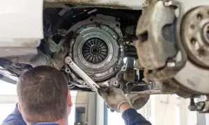 Mechanik dokonuje wymiany sprzęgła w samochodzie, używając klucza dynamometrycznego do precyzyjnego dokręcenia śrub.