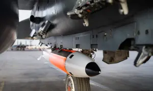 Podwieszona pod samolotem bomba lotnicza, pomarańczowo-szara, gotowa do akcji. To jest właśnie power bomb 4t, co daje jej moc.