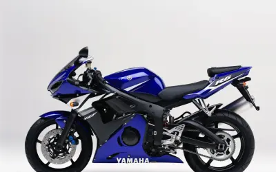 Niebieski motocykl sportowy Yamaha R6 2003 z białymi akcentami, gotowy do jazdy po torze.