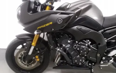 Czarny motocykl Yamaha FZ8N z żółtym napisem "FAZER" na owiewce. Złote lagi i detale podkreślają sportowy charakter.
