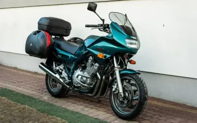 Zielony motocykl Yamaha XJ 900 z kuframi, gotowy na daleką podróż.
