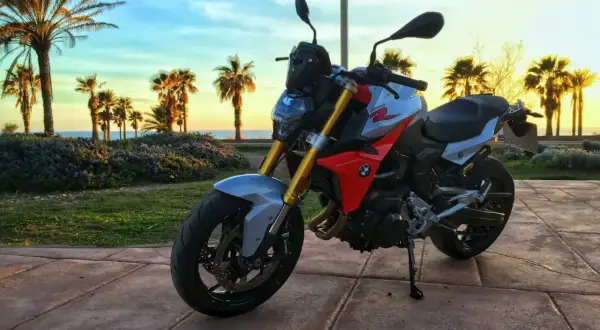 BMW F 900 R na tle palem i zachodzącego słońca nad morzem. Idealny motocykl na wakacyjne podróże.