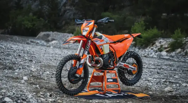 Pomarańczowy KTM EXC 300 2T na stojaku, gotowy do jazdy w terenie. Sprawdź jego dane techniczne!