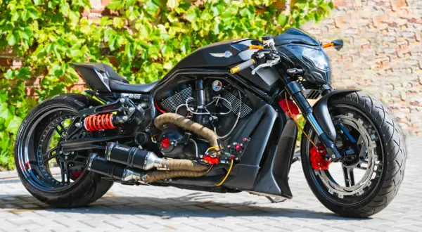 Czarny, sportowy motocykl z pomarańczowymi akcentami i podwójnym wydechem Akrapovič. Ten monowahacz to marzenie każdego fana motoryzacji.