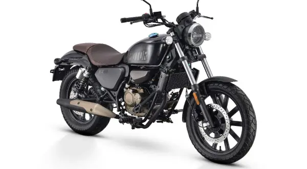 Czarny motocykl w stylu retro, z brązowym siedzeniem i złotymi elementami silnika. To najmocniejsze 125 na b, gotowe na każdą drogę.