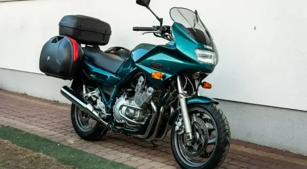 Zielony motocykl Yamaha XJ 900 z kuframi, gotowy na daleką podróż.