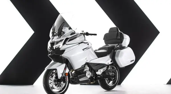 Biały, turystyczny motocykl z kuframi, jeden z nowoczesnych chińskich motocykli, prezentowany na tle czarno-białej grafiki.