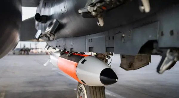 Podwieszona pod samolotem bomba lotnicza, pomarańczowo-szara, gotowa do akcji. To jest właśnie power bomb 4t, co daje jej moc.