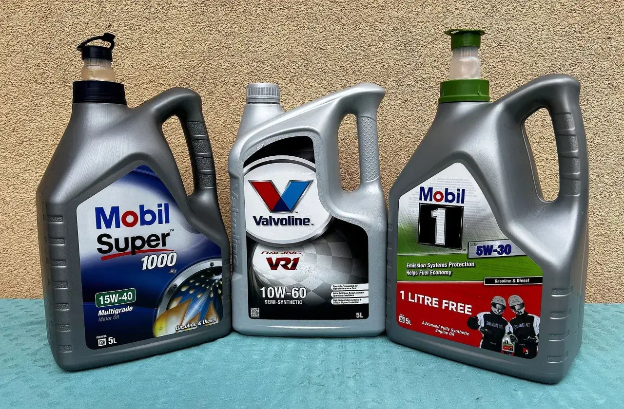 Trzy bańki z olejem silnikowym: Mobil Super 1000, Valvoline VR1 i Mobil 1. Wybór między olejem syntetycznym czy mineralnym zależy od potrzeb silnika.