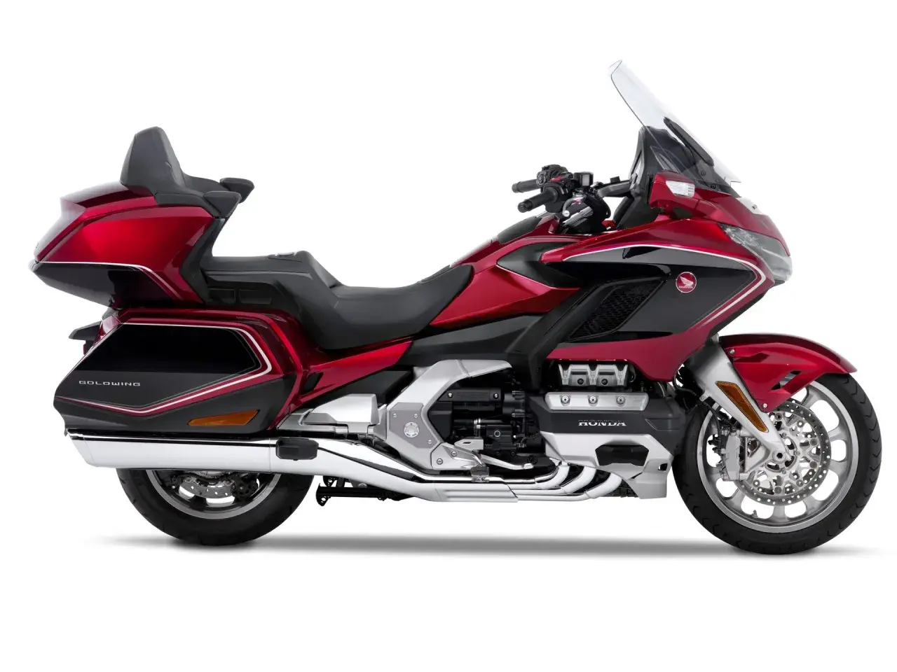Lśniący, czerwony motocykl Honda Goldwing z czarnymi akcentami i dużą szybą. Idealny na długie podróże.