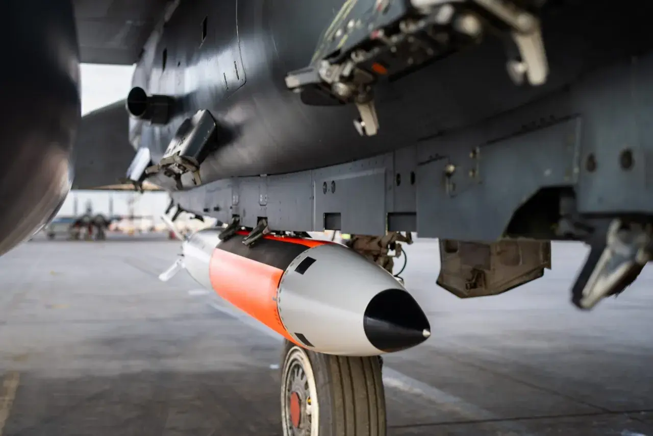 Podwieszona pod samolotem bomba lotnicza, pomarańczowo-szara, gotowa do akcji. To jest właśnie power bomb 4t, co daje jej moc.