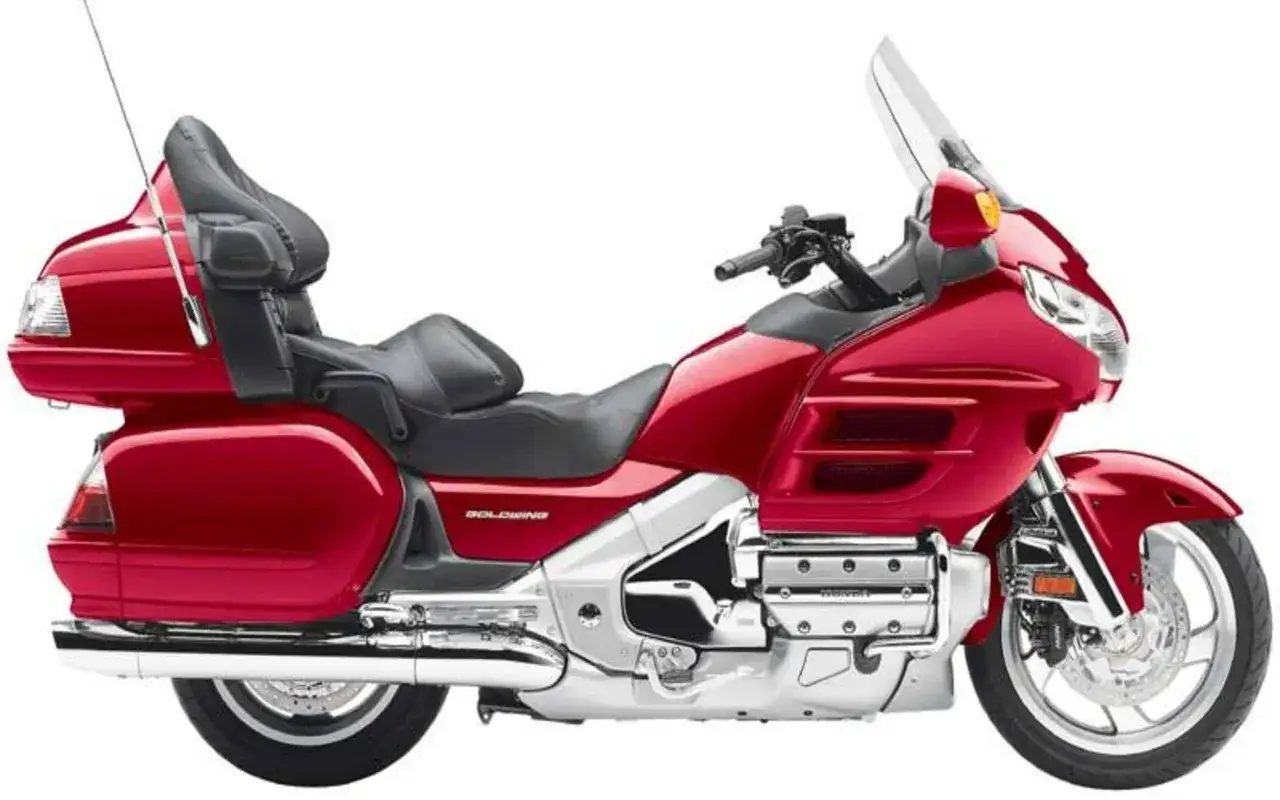 Czerwony motocykl Honda Goldwing z czarnym siedzeniem i dużą szybą. Idealny na długie podróże.