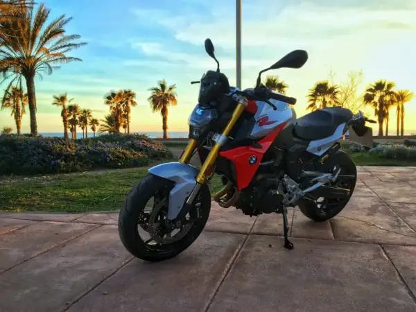BMW F 900 R na tle palem i zachodzącego słońca nad morzem. Idealny motocykl na wakacyjne podróże.