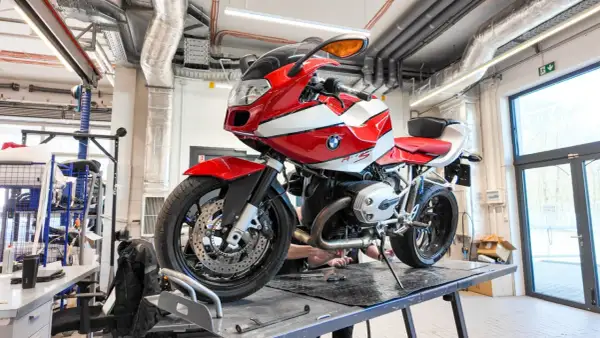 Czerwono-biały motocykl BMW R1200S na podnośniku w warsztacie.