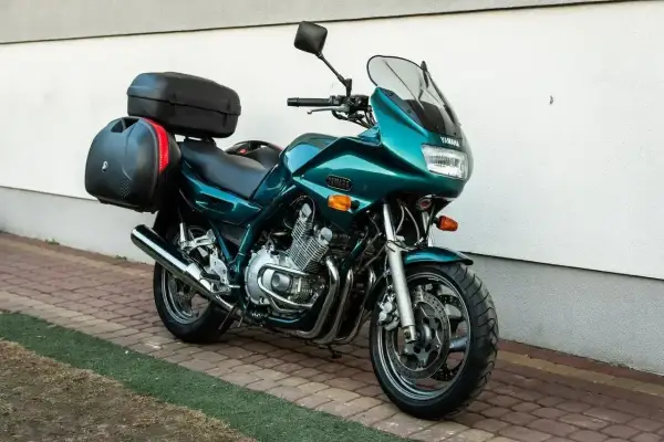 Zielony motocykl Yamaha XJ 900 z kuframi, gotowy na daleką podróż.